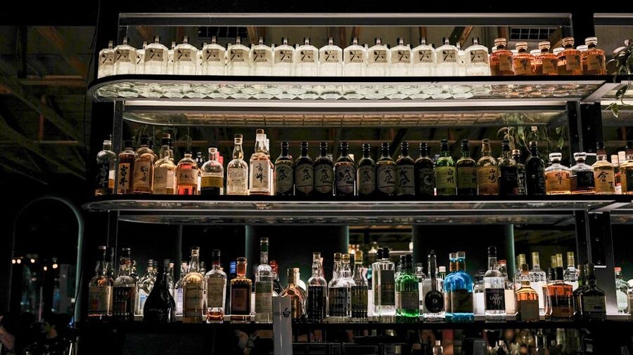 Japanese bar shelves lined with bottles, the kind that stock dozens of umeshu varieties