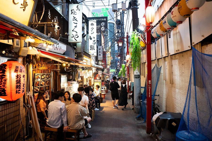 The narrow Omoide Yokocho alley in Shinjuku at night, packed with yakitori counters and lanterns