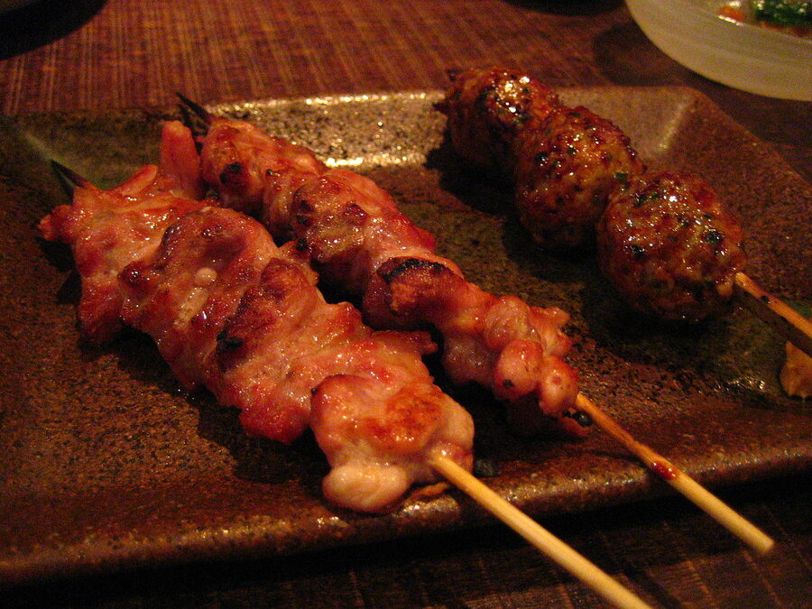 Skewers of seseri (chicken neck) and tsukune (meatball) on a plate at a Tokyo yakitori restaurant