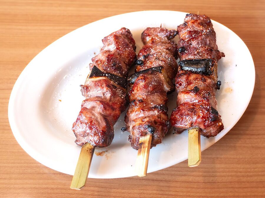 A salt-seasoned yakitori plate at a hot-spring counter in Aizu