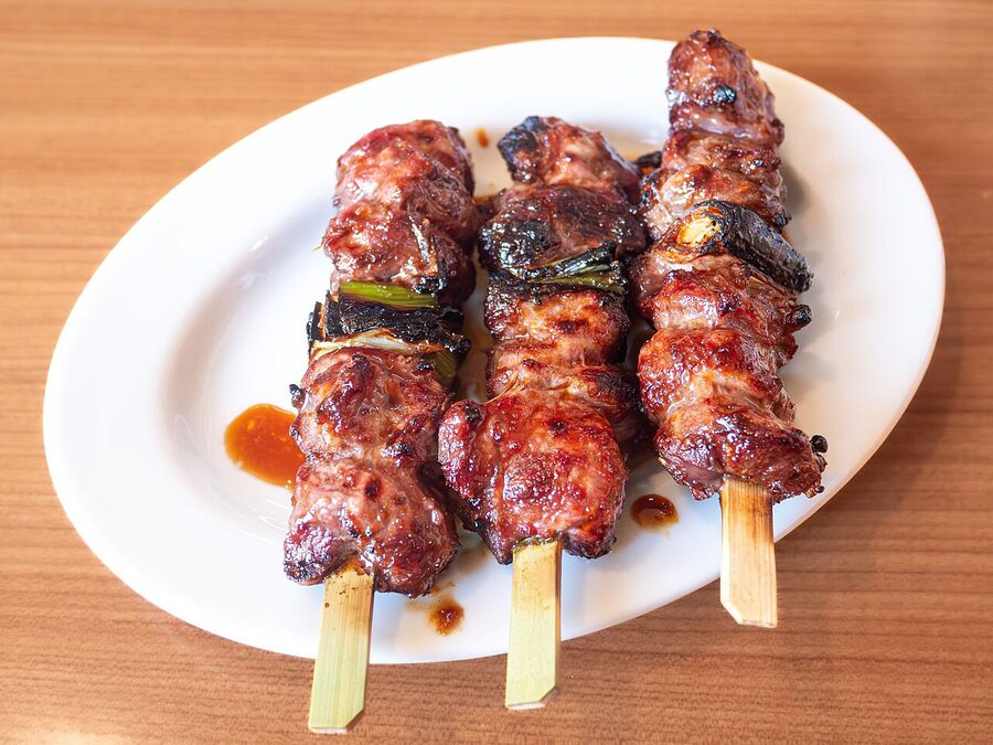 A tare-glazed yakitori plate, glossy and dark with the soy-mirin glaze