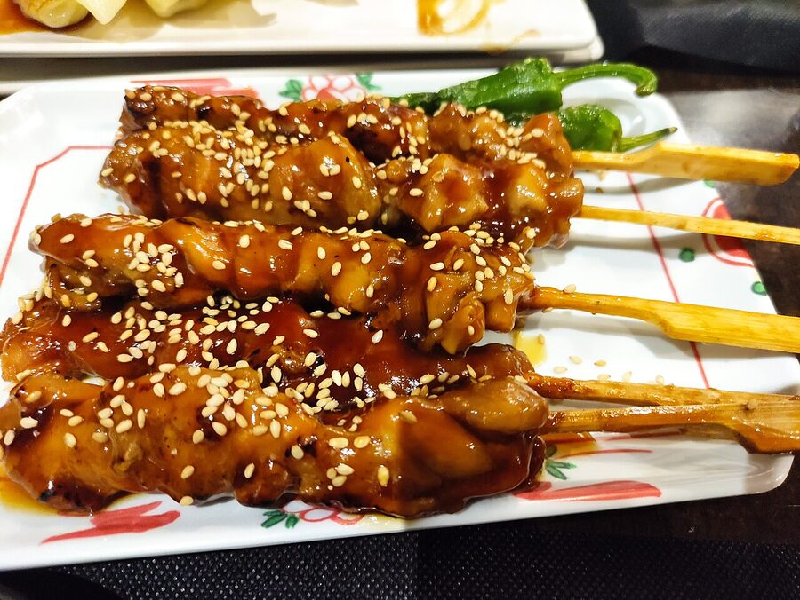An assortment of yakitori skewers ready to eat at a counter shop